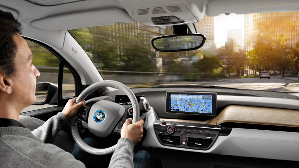 Pessoa utilizando o sistema de navegação BMW i enquanto dirige seu BMW i3, visão interna Pessoa utilizando o sistema de navegação BMW i enquanto dirige seu BMW i3, visão interna